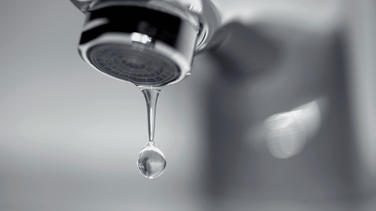 A water drop dripping from a faucet.