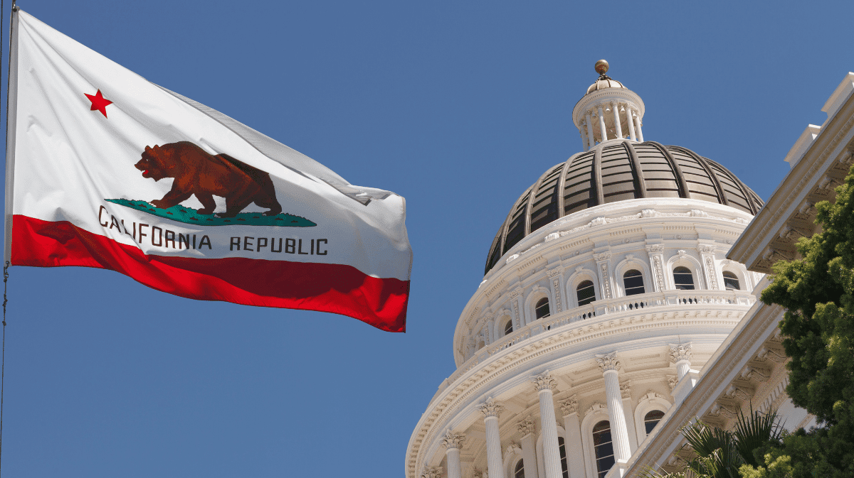 The California flag flys in front of the state capital.